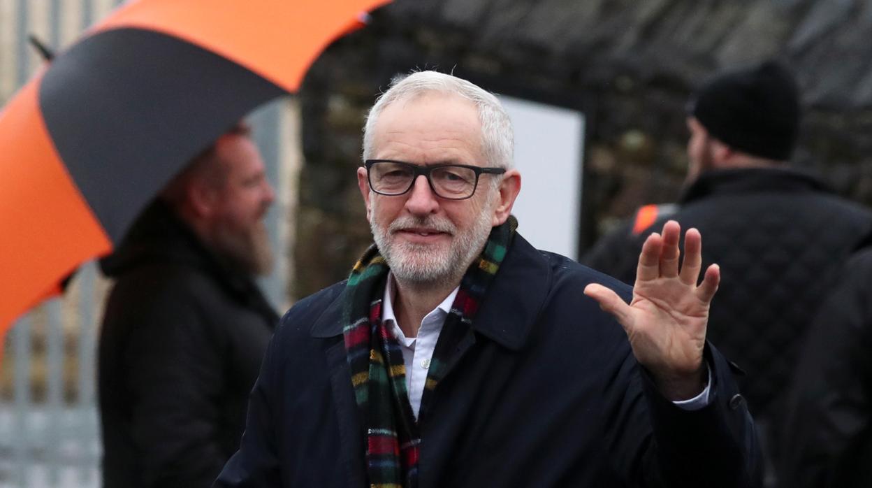 Jeremy Corbyn saluda a los fotógrafos que los esperan fuera de los depósitos de Amazon