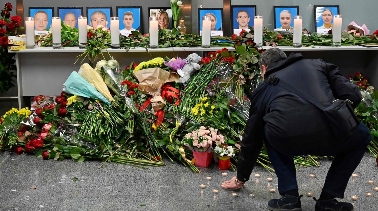 Un hombre pone flores en memoria de las víctimas del siniestro