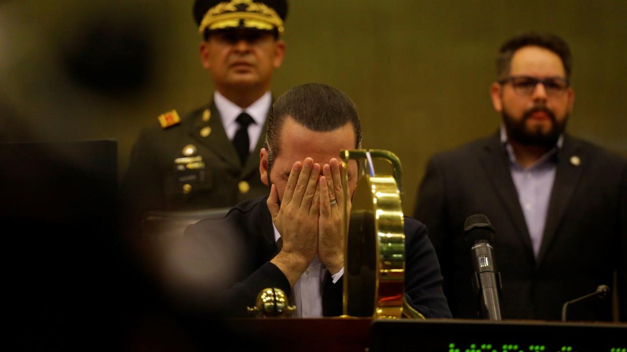 El presidente de El Salvador, Nayib Bukele, cubre su cara este domingo durante una sesión en el Congreso, en San Salvador (El Salvador)