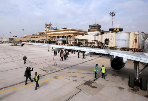 Personas cerca de un Airbus A320-200 de SyrianAir después de que aterrizara en el aeropuerto internacional de Alepo, Siria
