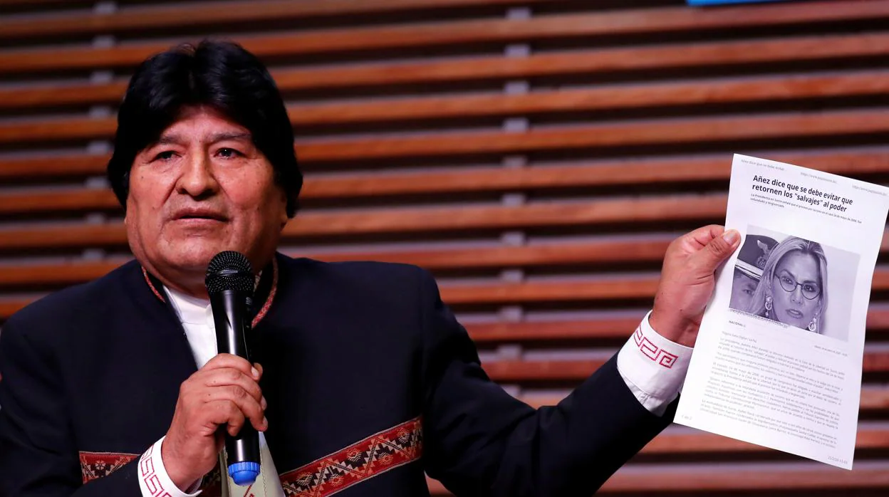 Evo Morales sostiene un papel con la imagen de la presidenta interina de Bolivia, Jeanine Áñez, durante una rueda de prensa en Buenos Aires