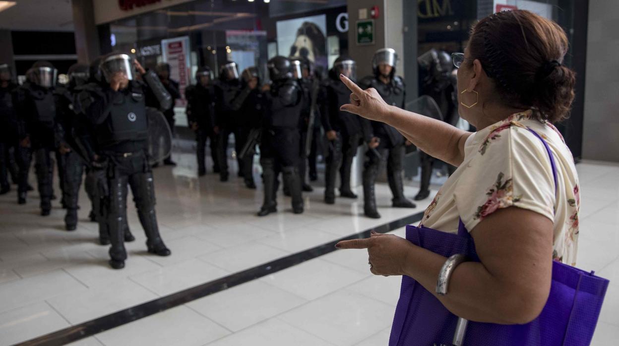 Una mujer se enfrenta a unos policías antidisturbios nicaragüenses