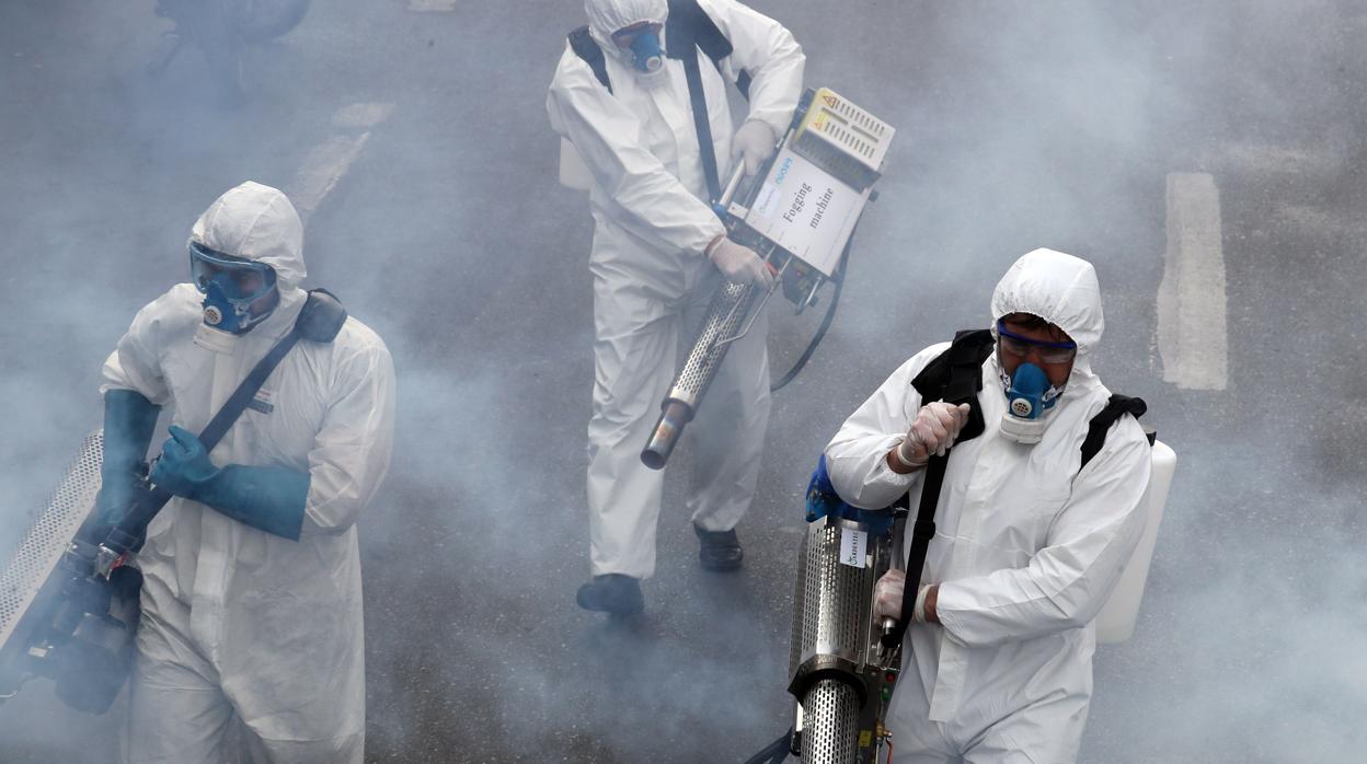 Un grupo de personas desinfectan las calles en Teherán para contener la epidemia