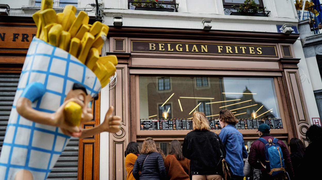 Un grupo de personas hace cola frente a un establecimiento de patatas fritas en Bruselas