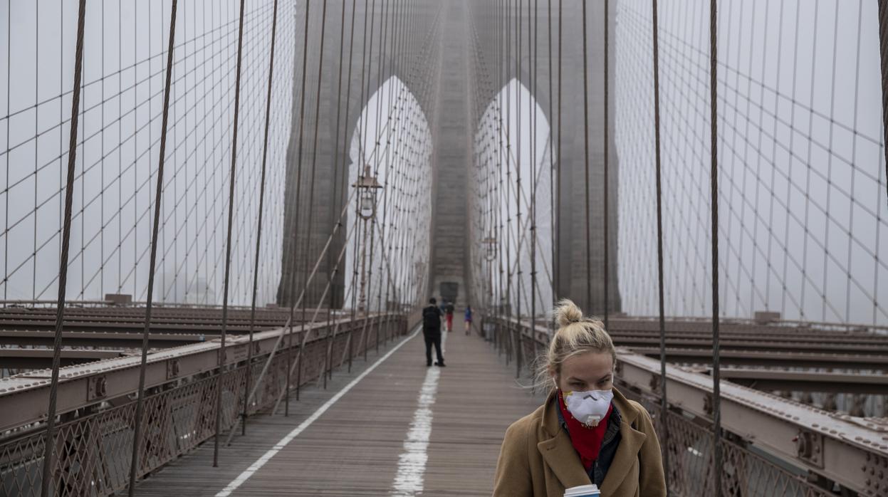 Una mujer atraviesa el puente de Brooklyn, en el que apenas se ven otros viandantes