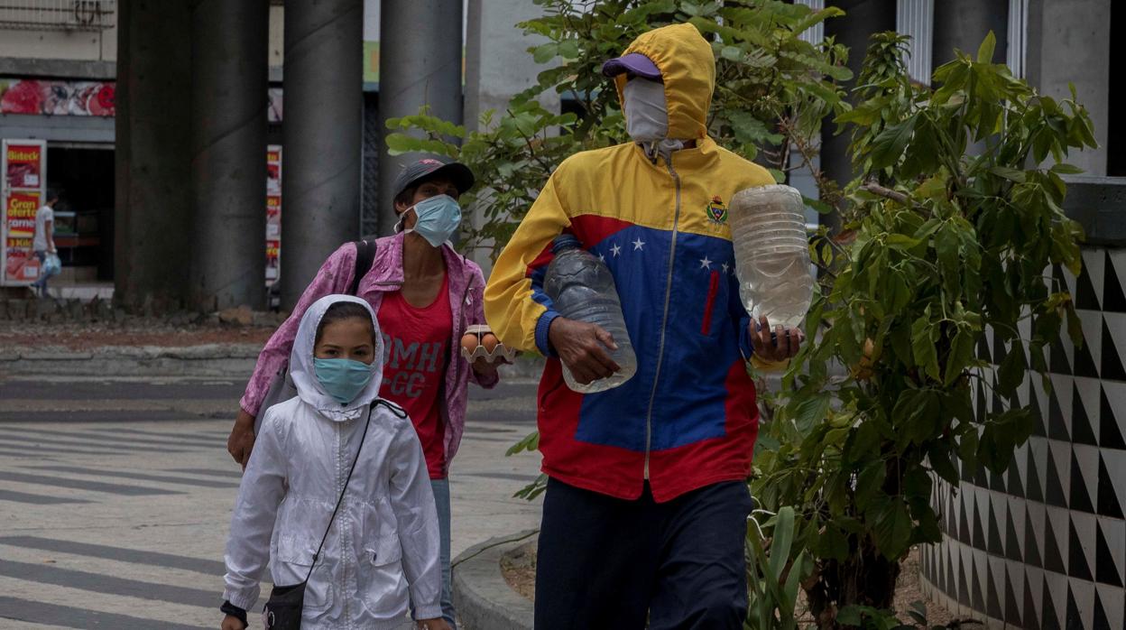 Una familia venezolana se protege con una mascarilla del coronavirus en Caracas
