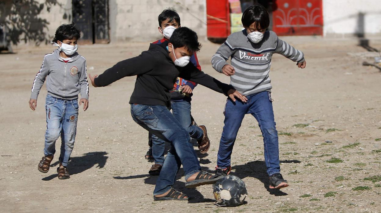 Niños jugando en Gaza con mascarilla