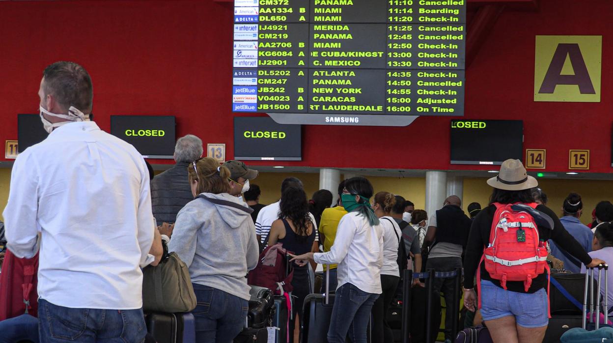 Viajeros hacen cola, este lunes, para tomar algún vuelo que salga de Cuba, que cerró sus fronteras el martes