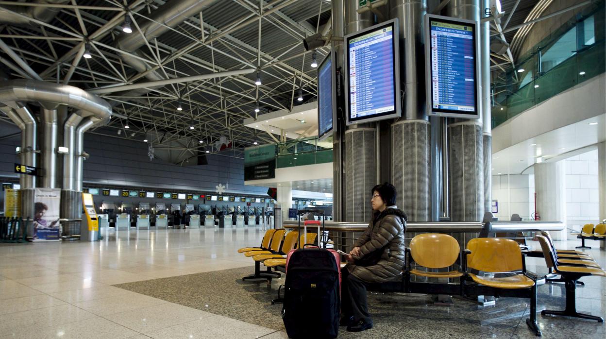 Foto de archivo de una mujer sentada en el aeropuerto de Lisboa