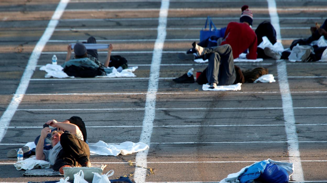 Un grupo de personas sin hogar descansa en el aparcamiento preparado en Las Vegas