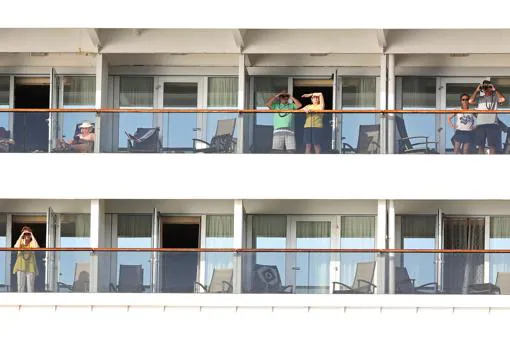 Pasajeros del Zaandam se asoman a los balcones mientras aguardan su futuro