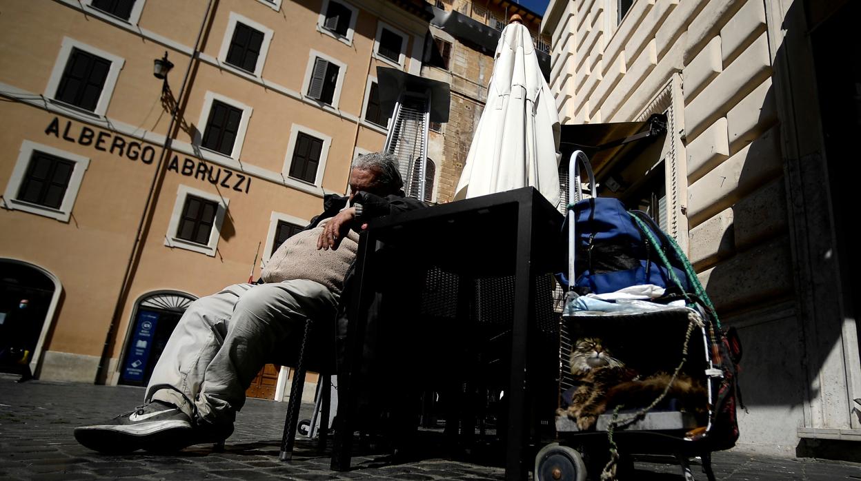 Un indigente duerme en una plaza de Roma