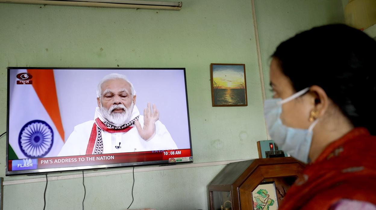 Una mujer escucha al primer ministro, Narendra Modi, anunciar la extensión de la cuarentena