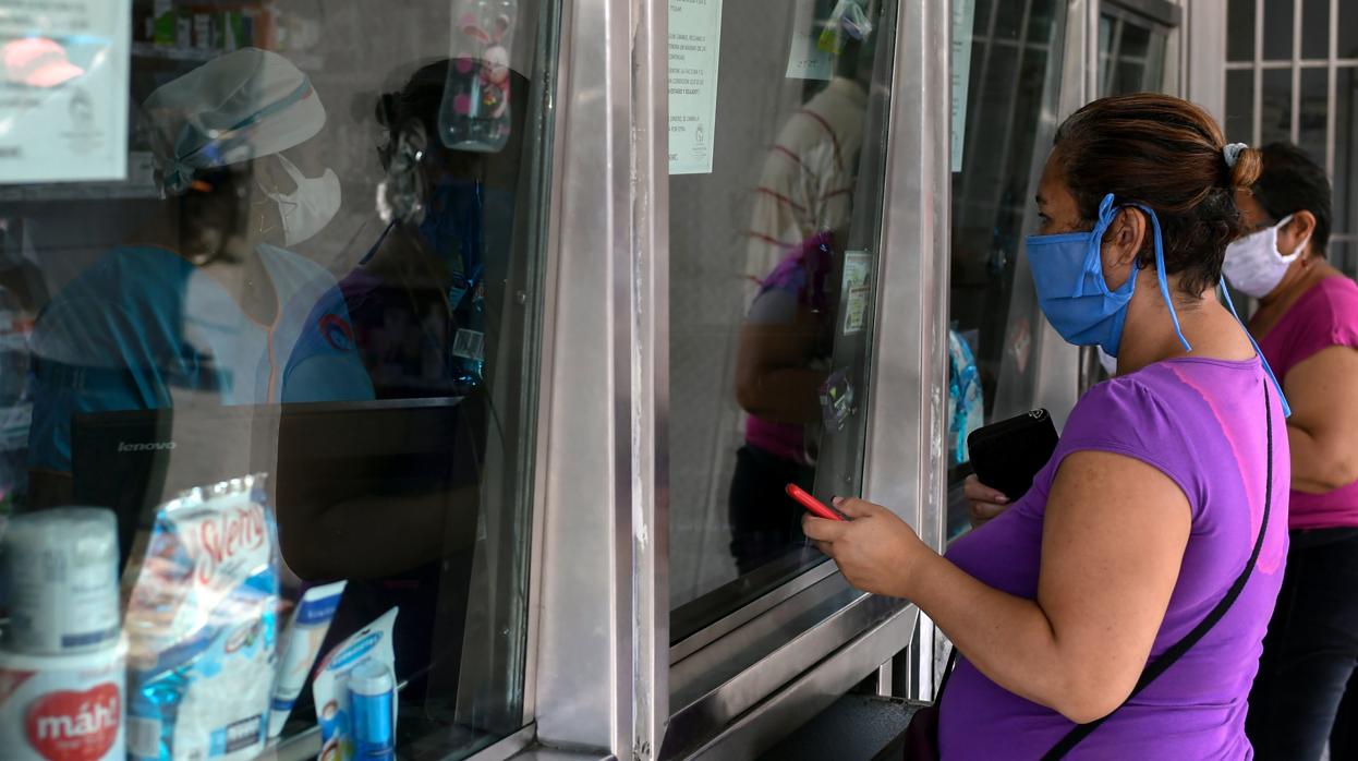 Dos mujeres compran en una farmacia en Los Teques, en el estado venezolano de Miranda