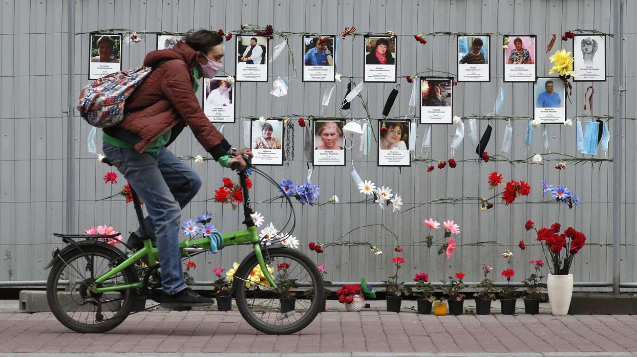 Un ciclista, junto a un memorial en honor de médicos fallecidos por los contagios