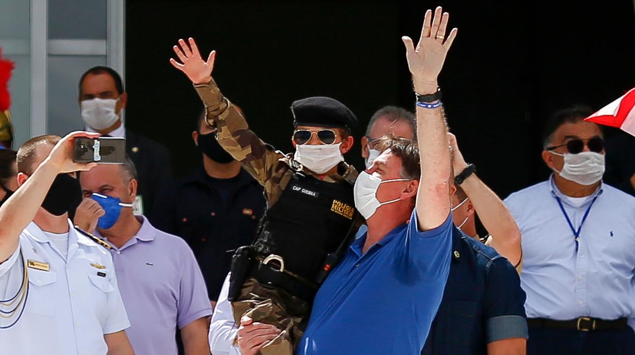 El presidente Bolsonaro, con un niño en brazos, durante una concentración el domingo en Brasilia