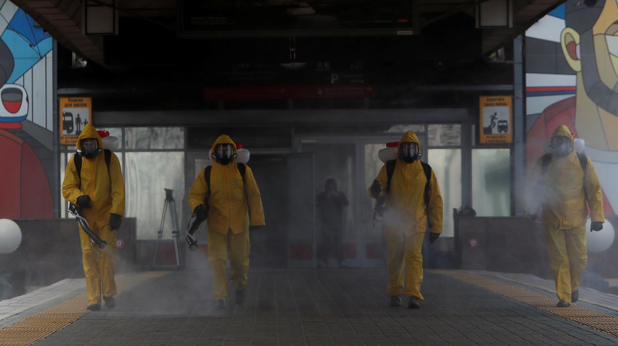 Un grupo de operarios desinfectan una estación de Moscú