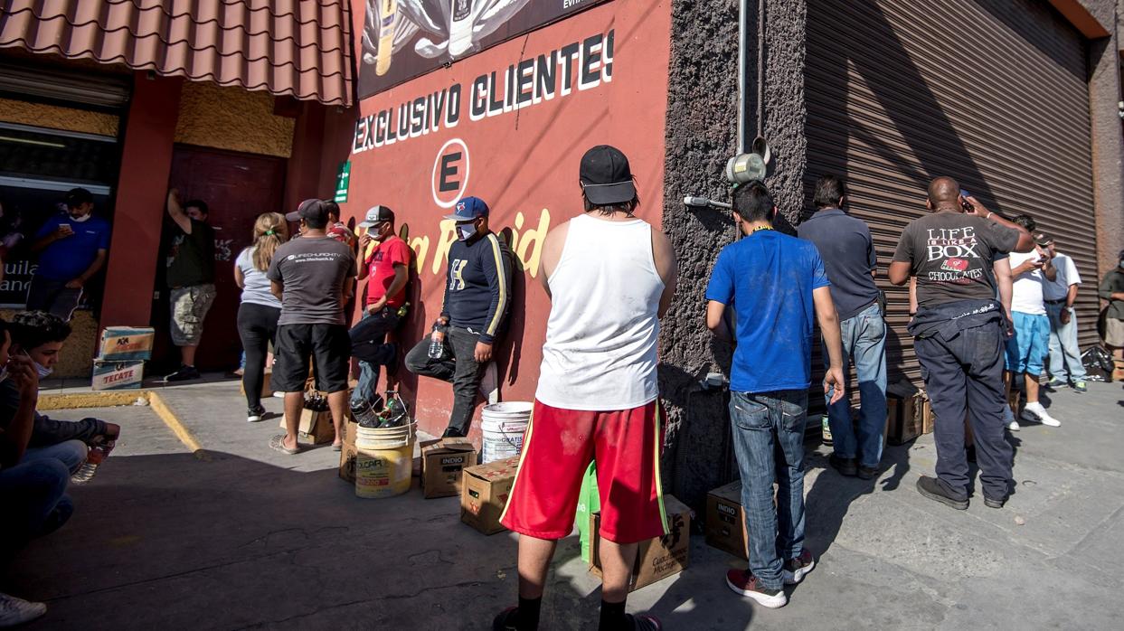 Una fila de hombres espera para comprar licores y cervezas este lunes, en el estado de Coahuila, tras comenzar la reapertura de las tiendas