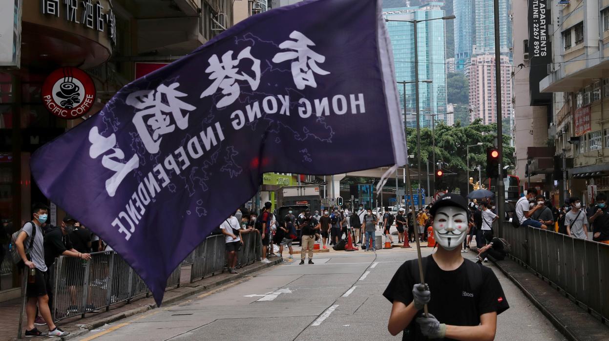 Un manifestante con una máscara sostiene una bandera que dice Independencia de Hong Kong