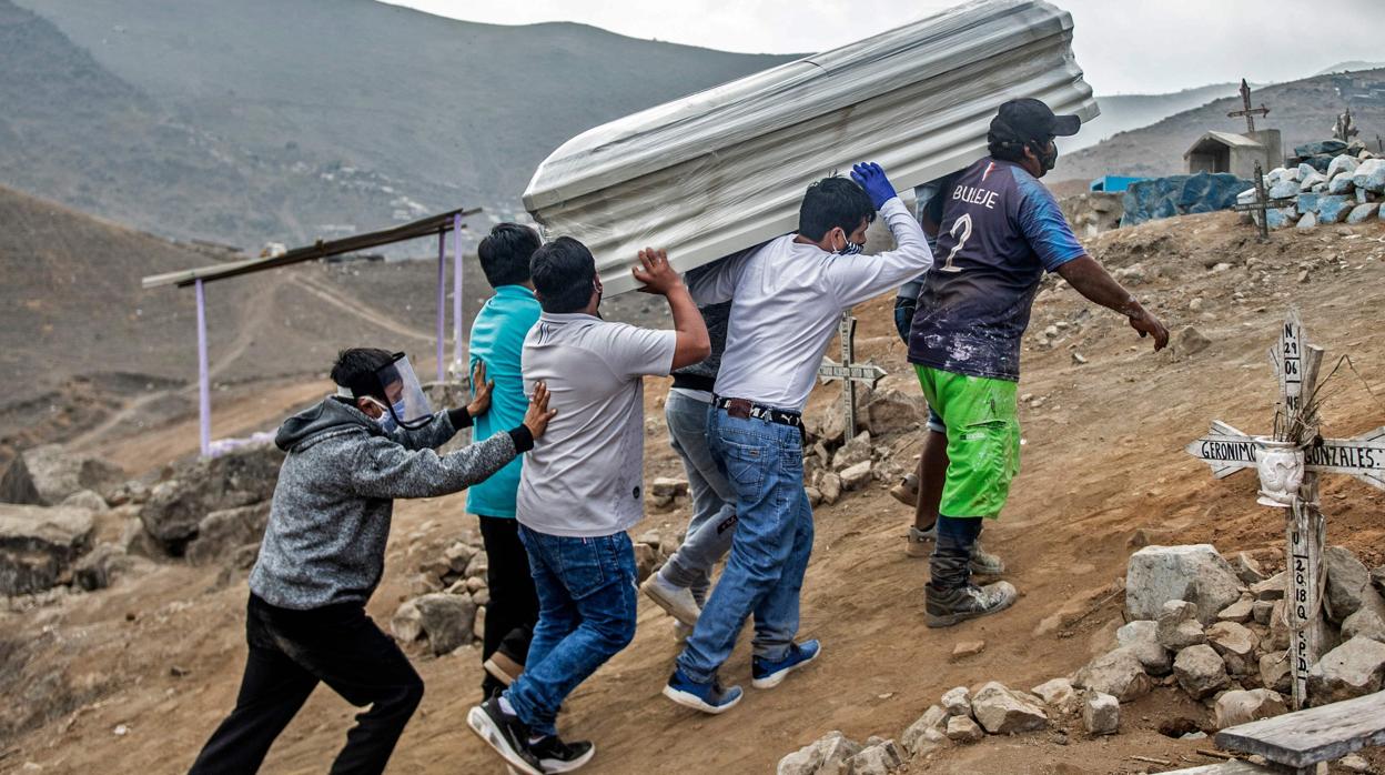 Un grupo de hombres llevan el ataúd de una víctima del coronavirus en Perú