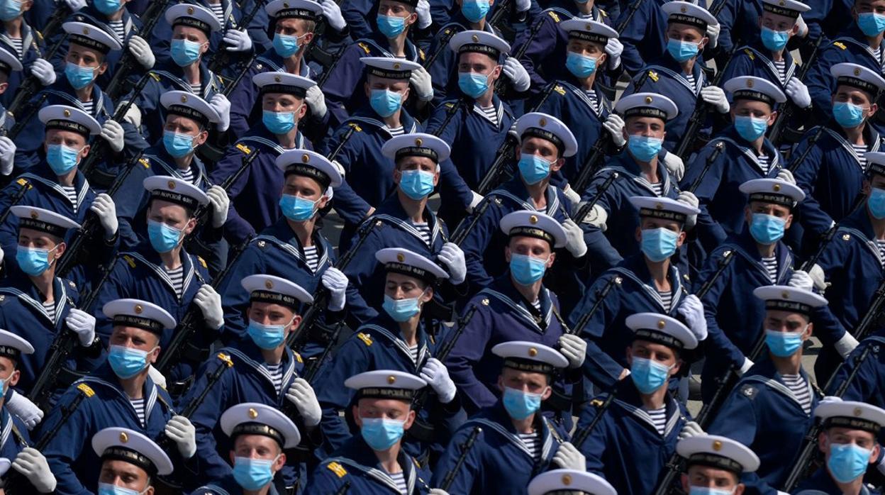 Un grupo de militares rusos desfilan durante un ensayo protegidos con mascarillas