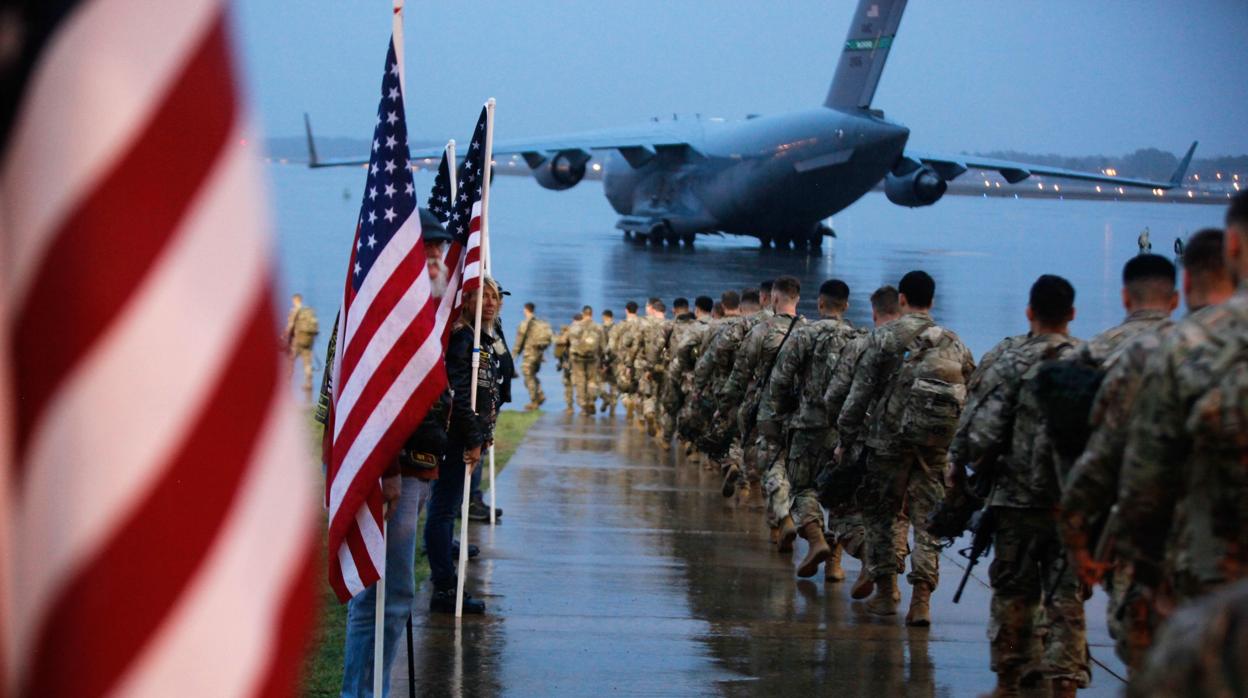 Un grupo de paracaidistas marchan para abordar un avión civil con destino al área de operaciones del Comando Central de EE. UU.