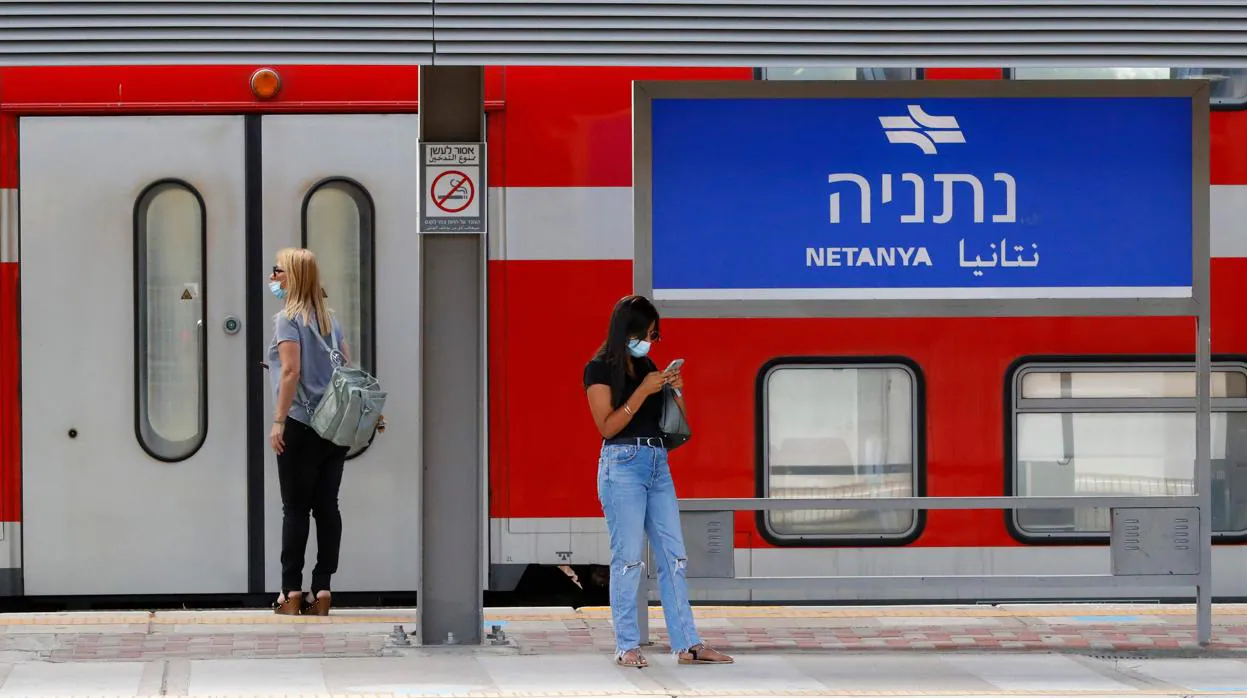 Una mujer espera el tren en la ciudad de Netanya