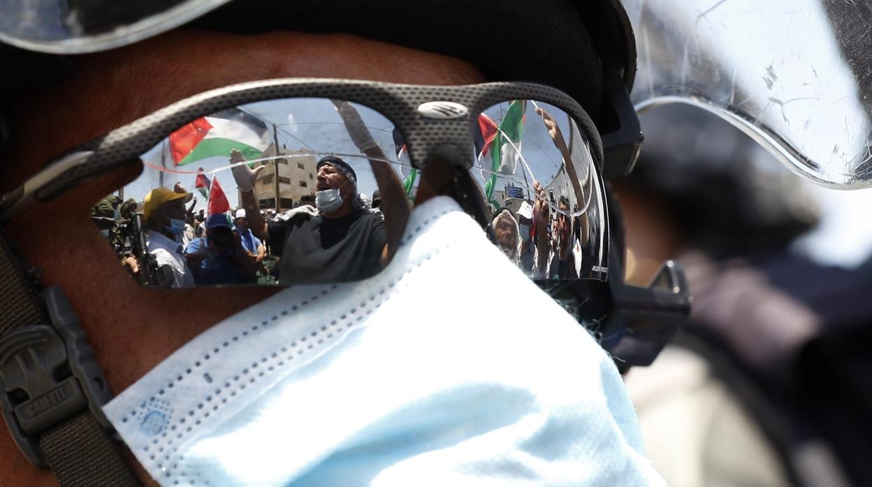 Manifestantes palestinos se reflejan en las gafas de un soldado durante una protesta en Salfit (Gaza y Cisjordania)