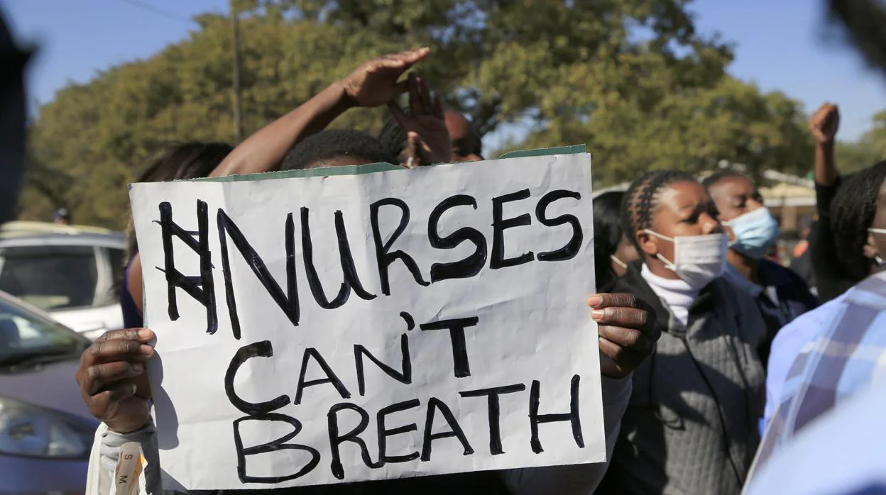 Una enfermera sostiene un cartel durante una protesta para exigir un aumento salarial en Zimbabue