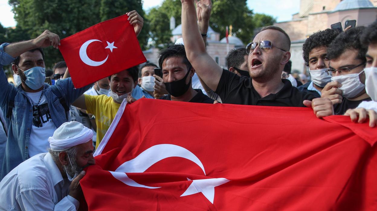 Un grupo de ciudadanos turcos se manifiestan con la bandera de su país en Estambul