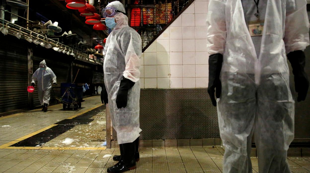 Un grupo de trabajadores desinfecta un mercado de Hong Kong