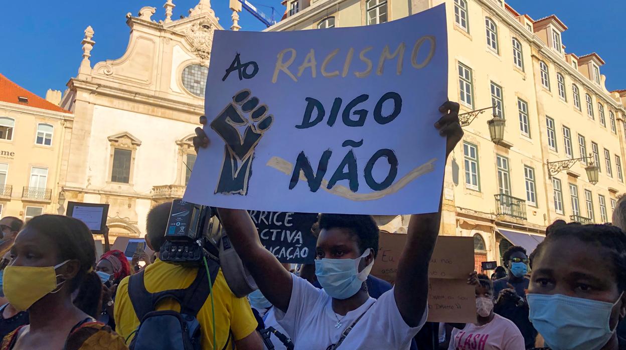 Un manifestante sostiene una pancarta donde se lee «Al racismo digo no», en Lisboa