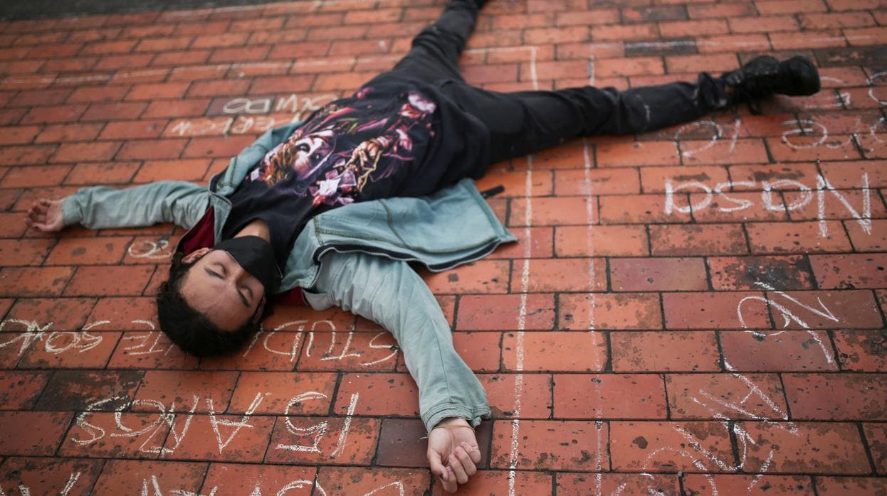 Un manifestante se tumba en el suelo durante una protesta contra el incremento de matanzas en Colombia
