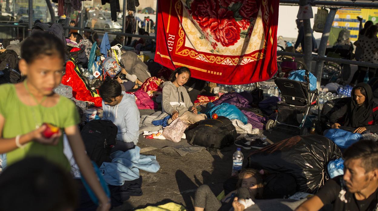 Un grupo de personas acampa a las afueras del quemado campamento para refugiados de Moria