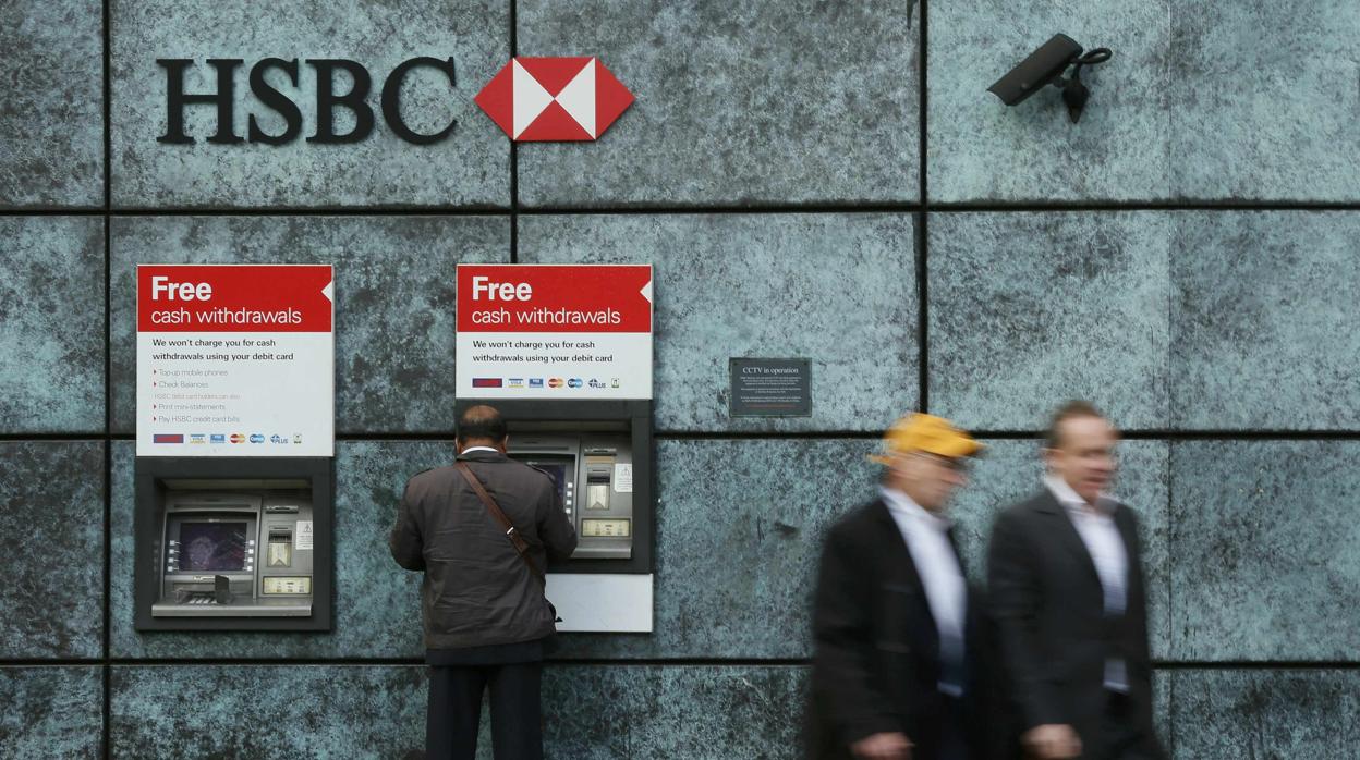 Un hombre saca dinero del cajero del banco HSBC, en el centro de Londres
