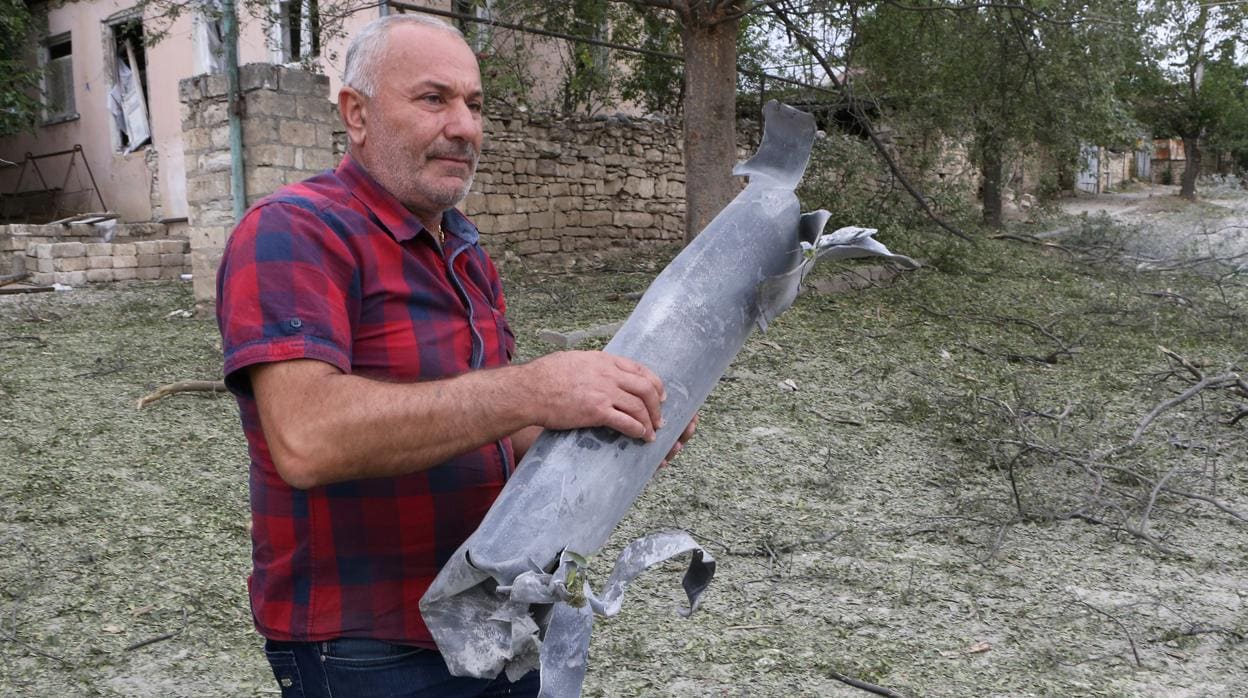 Un hombre sostiene restos de armamento en Nagorno Karabaj, después de la ofensiva de Azerbaiyán