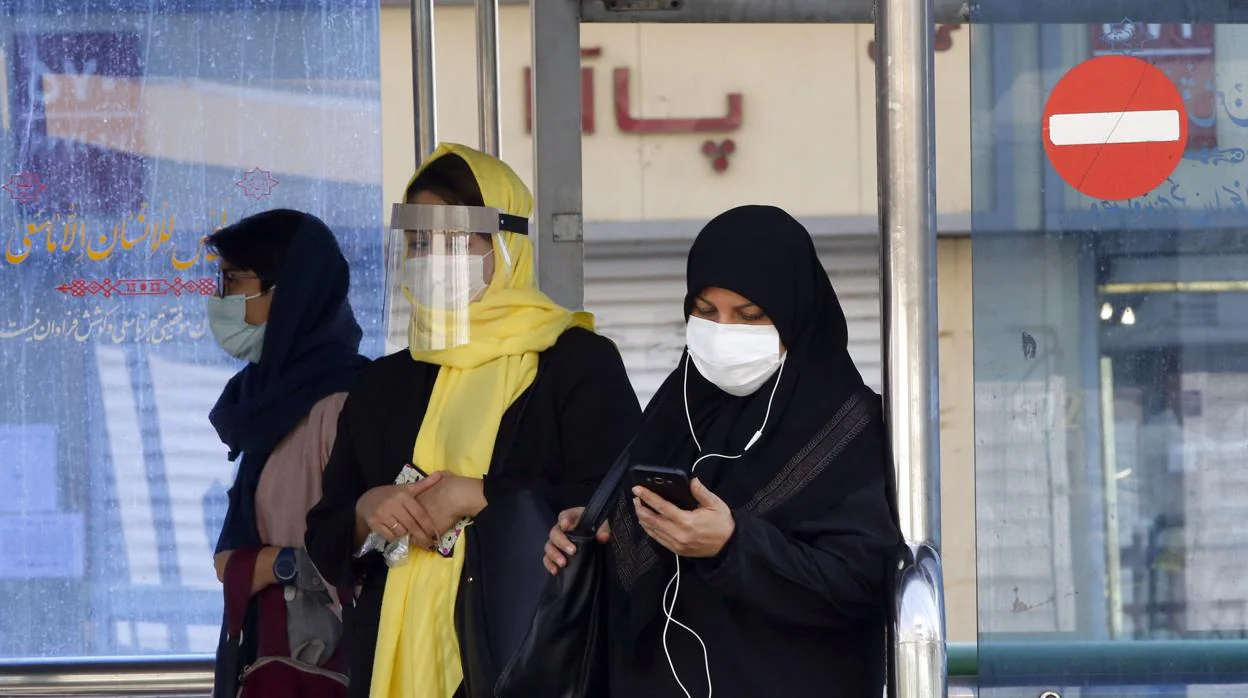 Grupo de mujeres con mascarilla, paseando por Teherán
