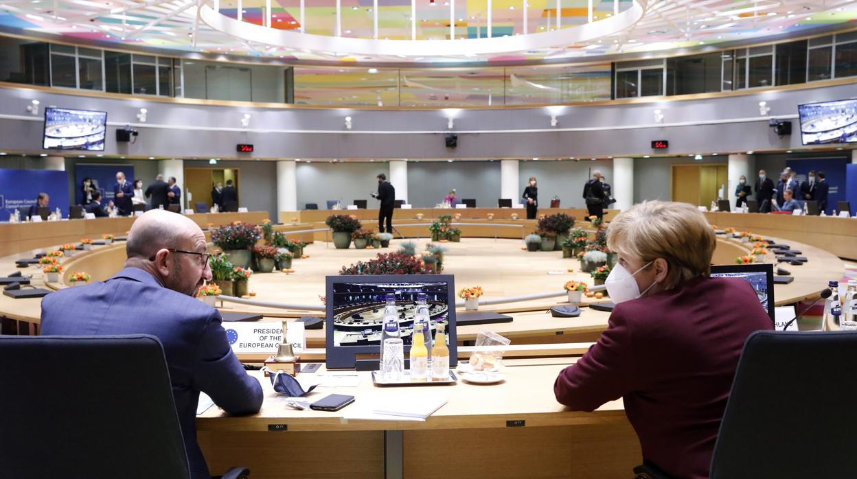 El presidente del Consejo Europeo, Charles Michel, habla con la canciller alemana, Angela Merkel, en la segunda jornada de la cumbre