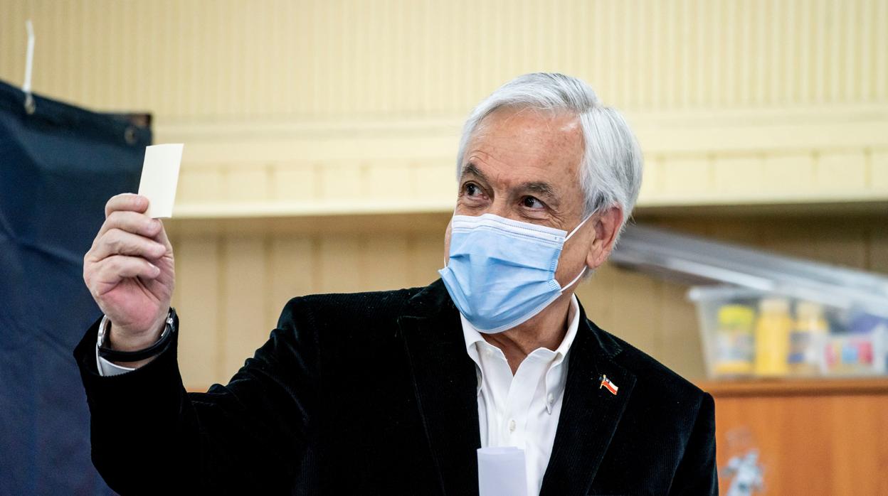 El presidente de Chile, Sebastián Piñera, muestra su papeleta antes de votar en el plebiscito