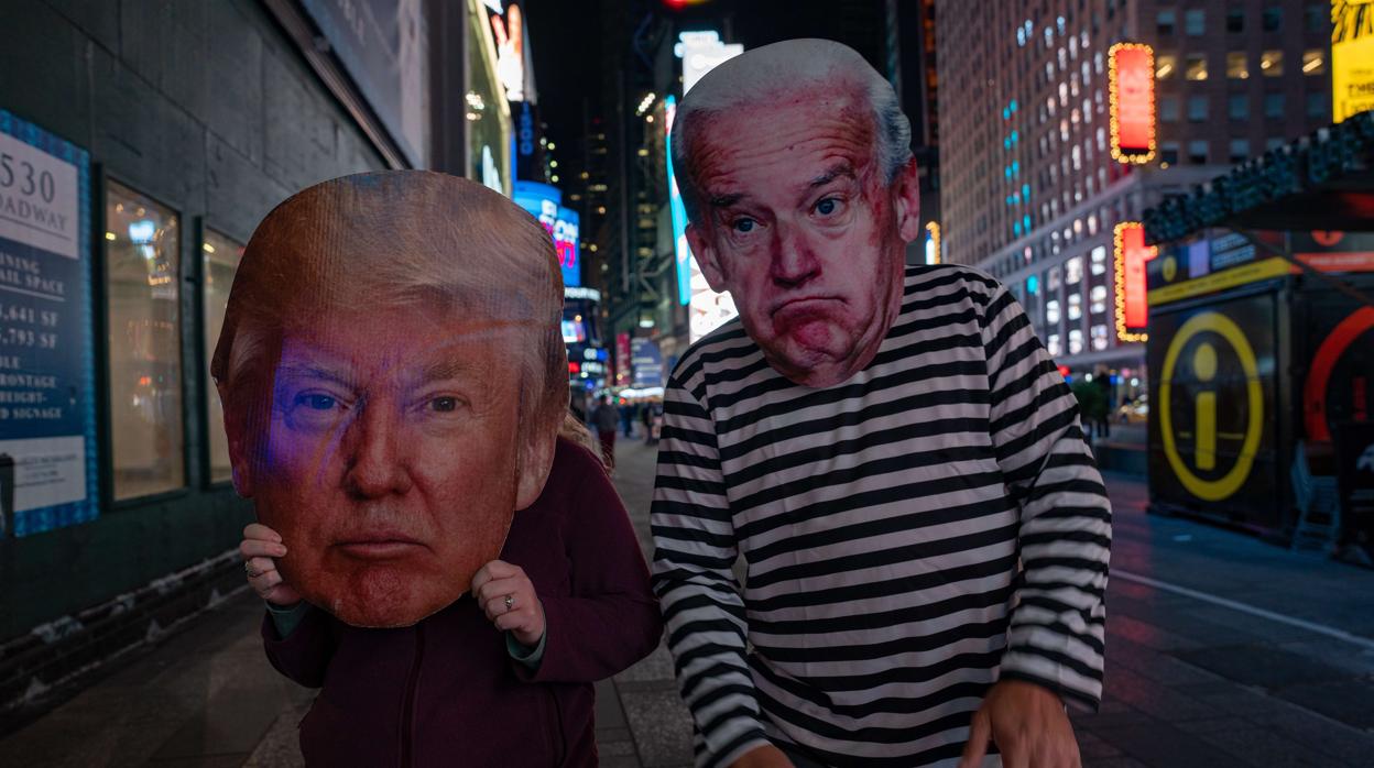 Dos personas pasean por Nueva York con caretas de Trump y Biden