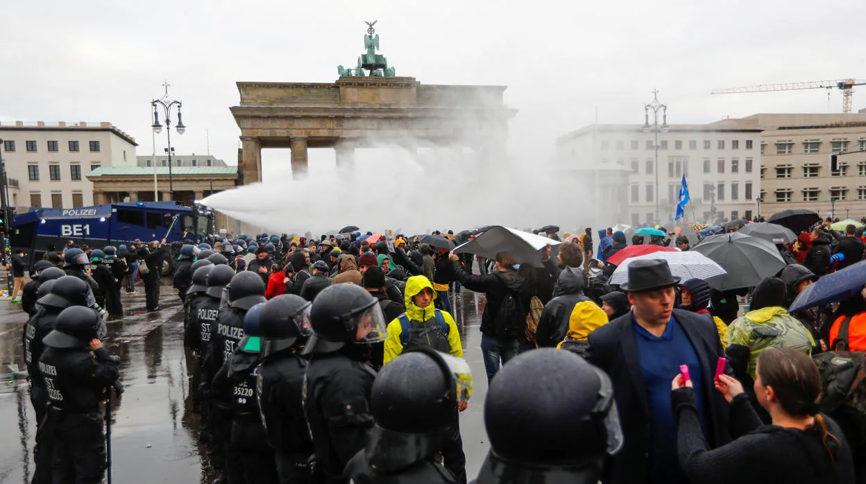 La policía alemana intenta disolver con cañones de agua a los manifestantes ante la Puerta de Brandenburgo, en Berlín