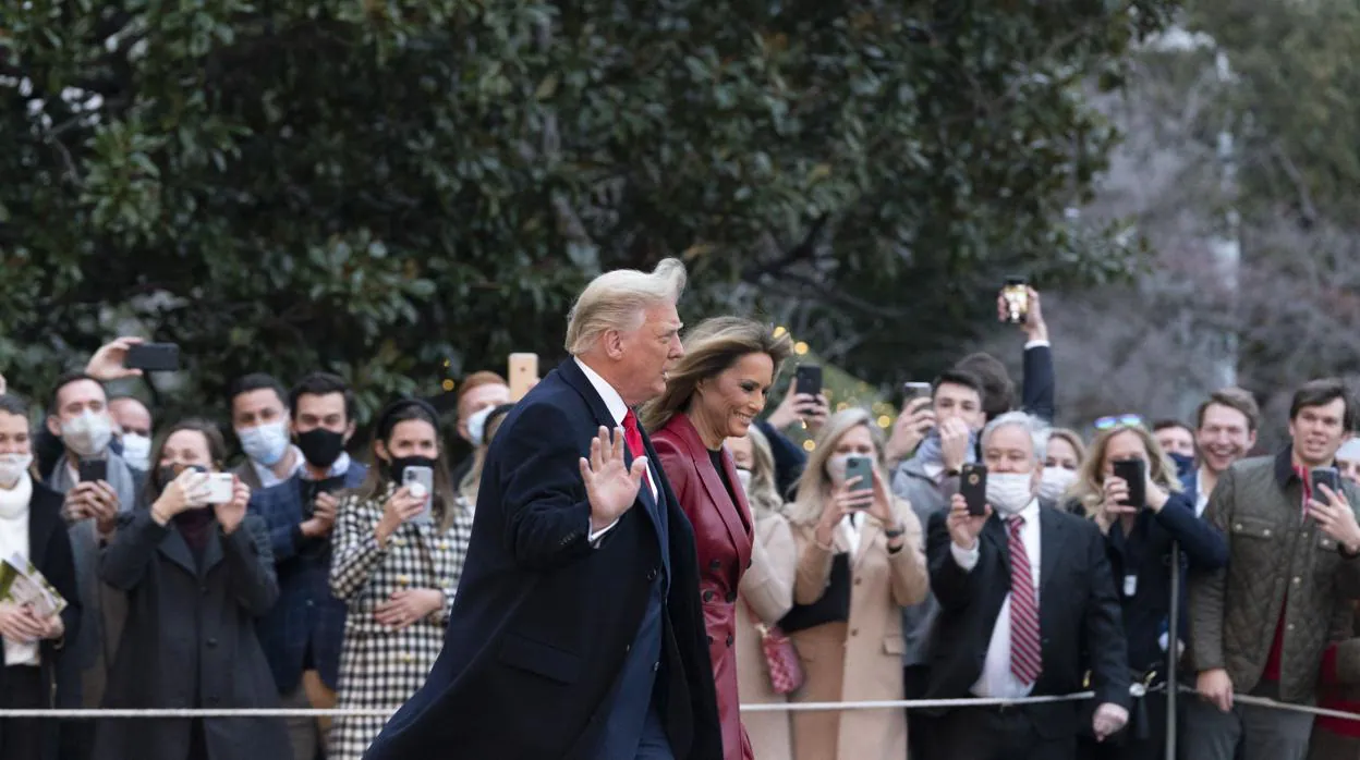 Un grupo de simpatizantes saludan a Donald y Melania Trump, mientras estos salen de la Casa Blanca
