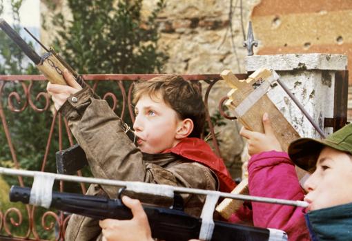 Niños jugando con simulacros de armas fabricadas por ellos mismos