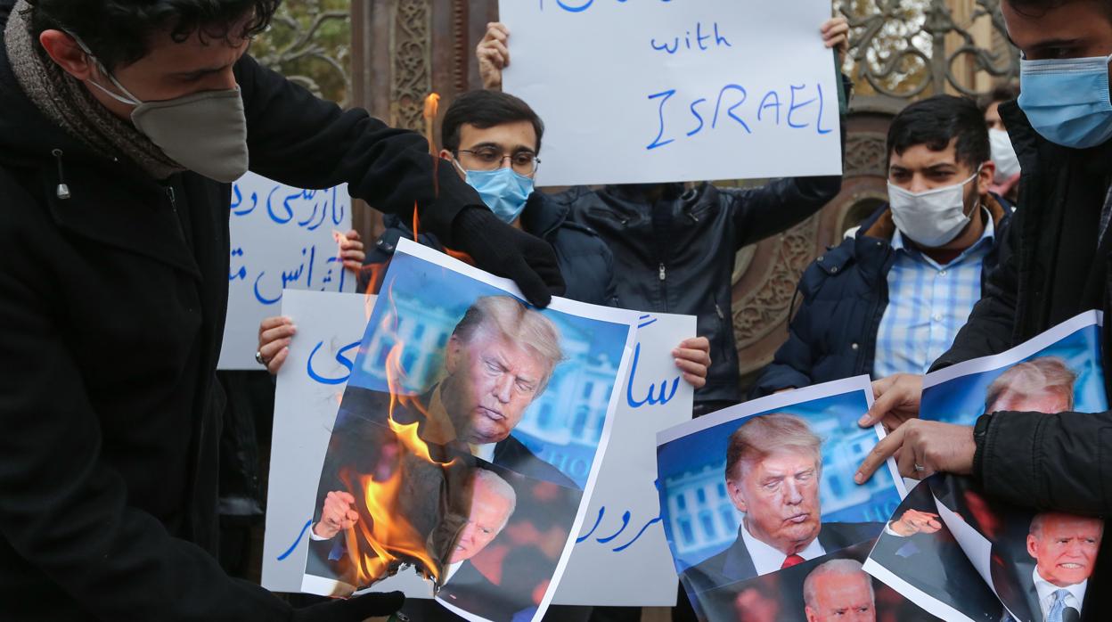 Un grupo de manifestantes iraníes queman fotografías de Biden y Trump