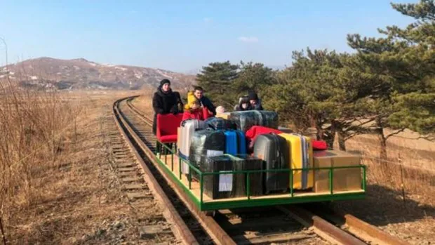 Un grupo de diplomáticos rusos huye de Corea del Norte empujando un carro por las vías del tren