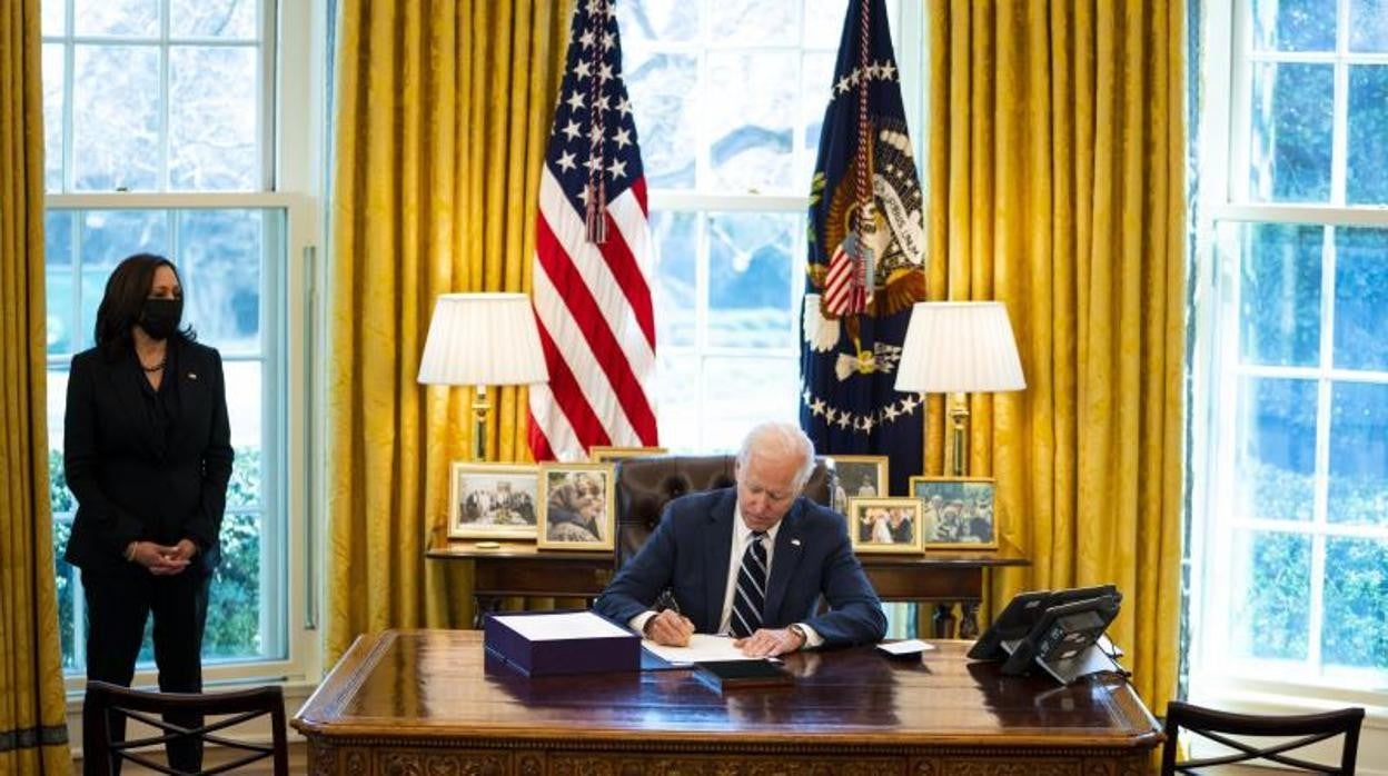 El presidente de EE.UU., Joe Biden, firma ante la vicepresidenta, Kamala Harris, el plan de rescate por el Covid