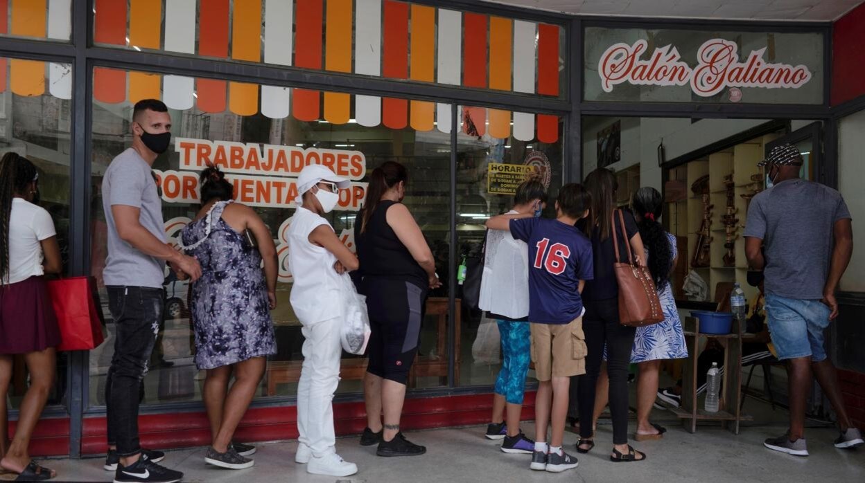 Los cubanos hacen cola para poder adquirir productos en una tienda en La Habana