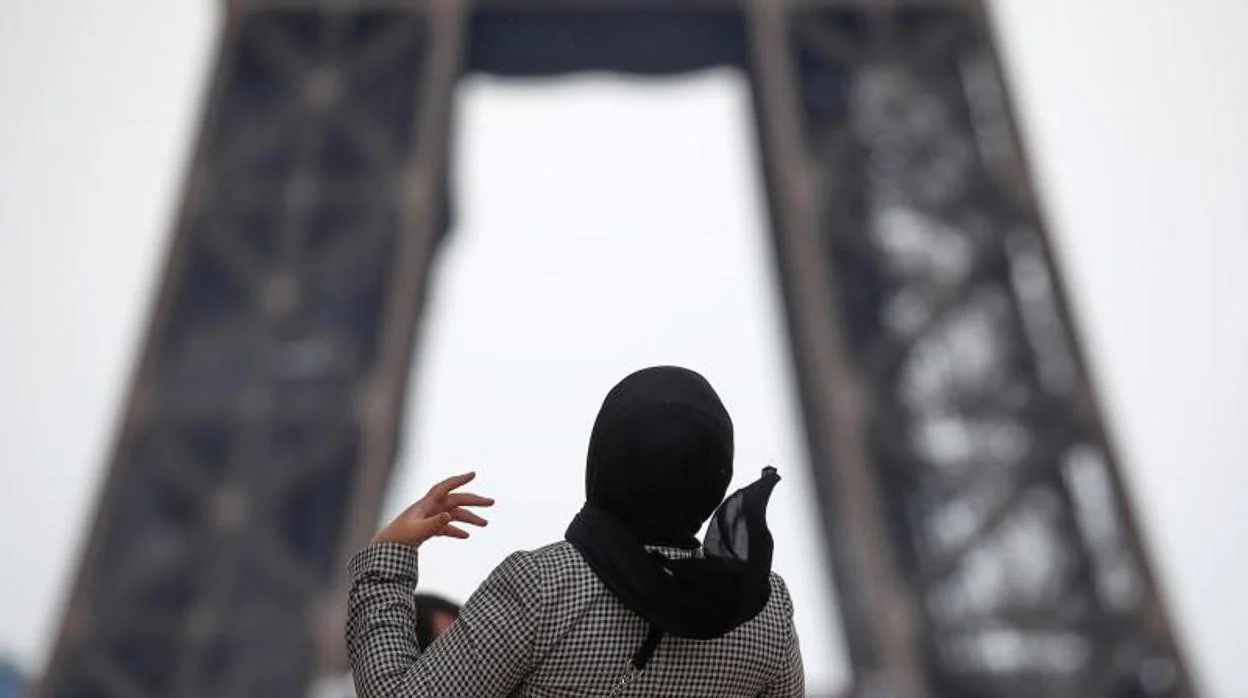 Una mujer velada camina por Trocadero, frente a la Torre Eiffel