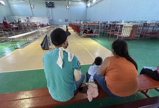 Lázaro Montenegro y su familia en el gimnasio habilitado como refugio, que cuenta con decenas de literas