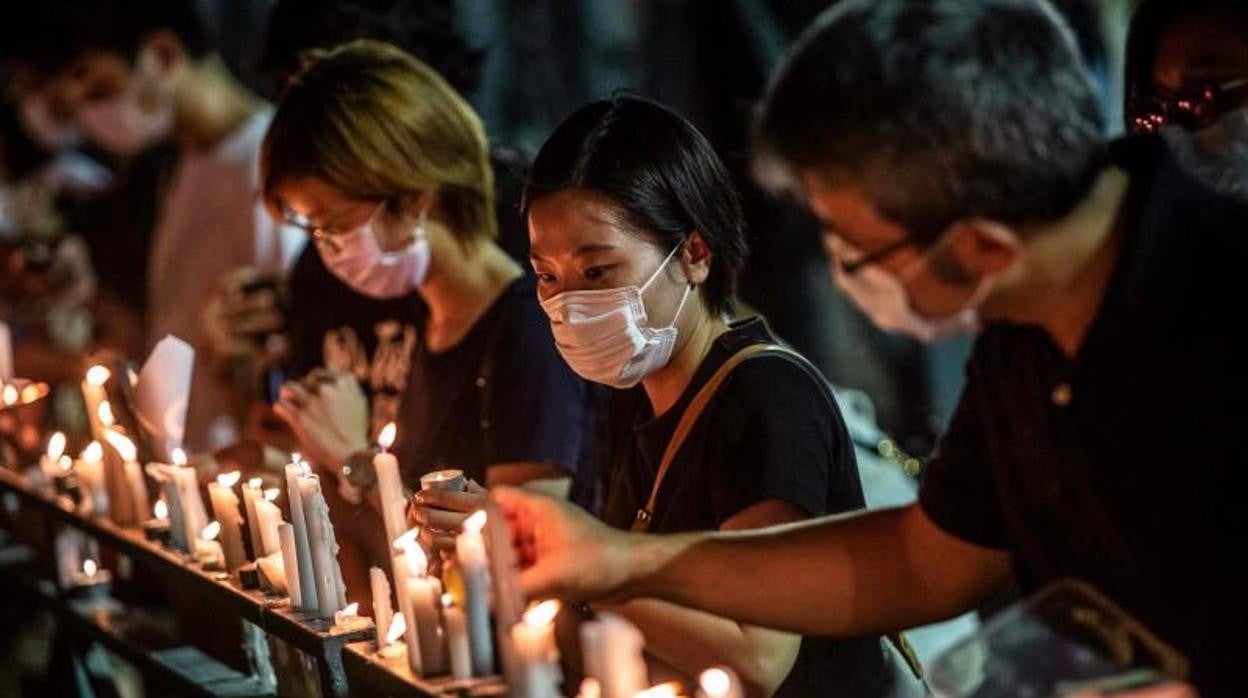 Tras la vigilia anual de conmemoración, una mujer coloca una vela en Victoria Park, Hong Kong, en 2020